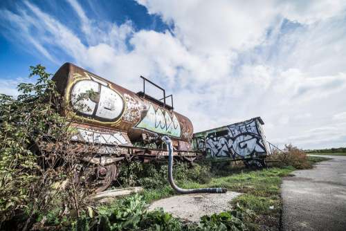 Rusted Wagon with Grafitti Art Alone in The Field