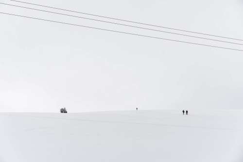 Snow Covered Hill with Tiny Cross-Country Skiers