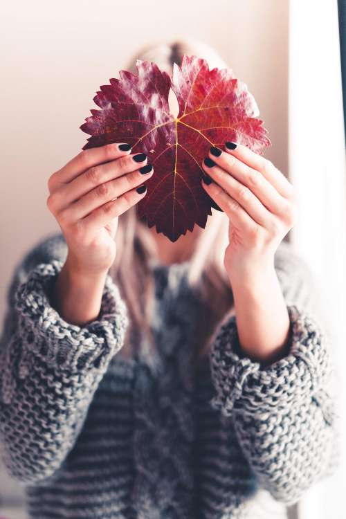 Woman Holding an Autumn Leaf