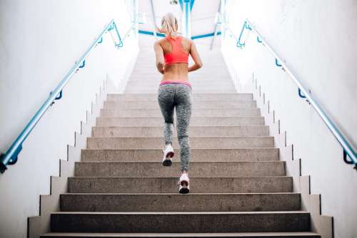 Young Fitness Girl Running Up The Stairs