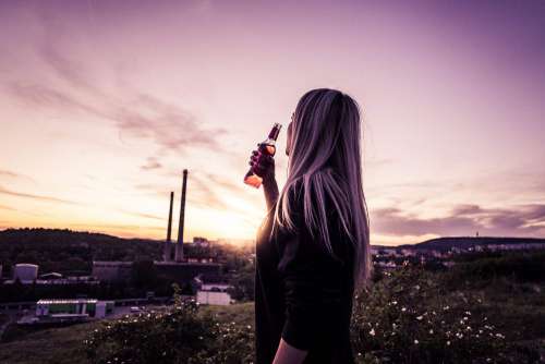 Young Woman Enjoying a Drink in Sunset
