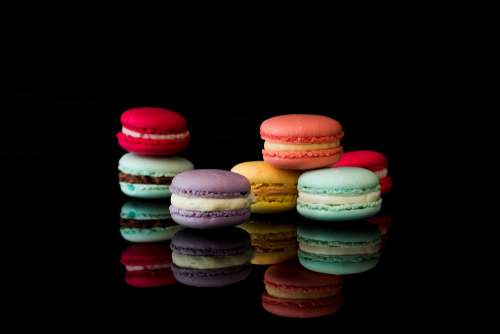 Yummy Macarons on Black Glossy Background Isolated