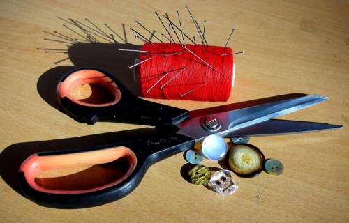 Scissors Sewing Coil Buttons On The Table Pins