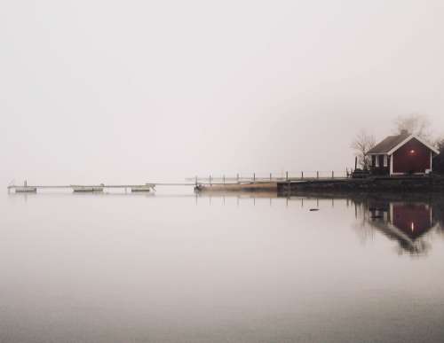 A Small House OverLooking A Misty Lake Photo