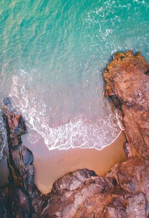 Aerial View Of Sea Rolling Into A Rocky Shore Photo
