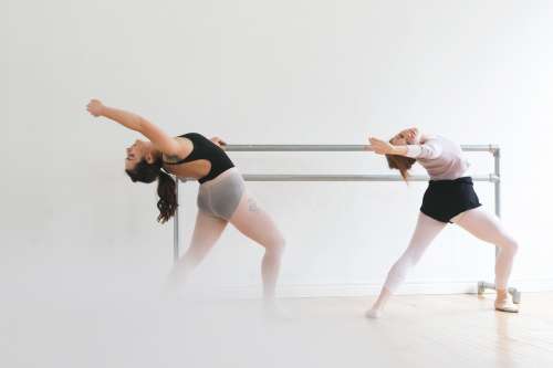 Ballet Dancers Warm Up At Bar Photo