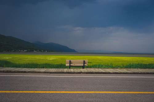 Bench Overlooking Farm Field And Oncoming Storm Photo