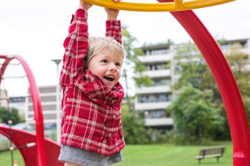 Boy Hanging At Playground Photo