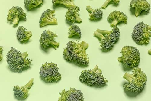 Broccoli Pieces On Green Surface Photo