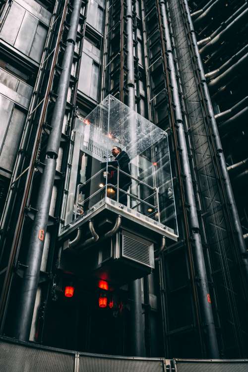 Businessman In Glass Elevator Going Up Photo