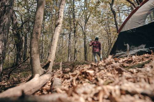 Camper Standing Beside Tent With Axe Photo