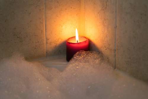 Candle Burning By Bubble Bath Photo