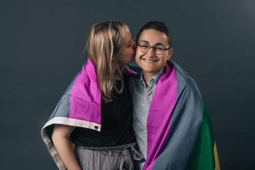 Couple Wrapped In Pride Flag Kiss Photo