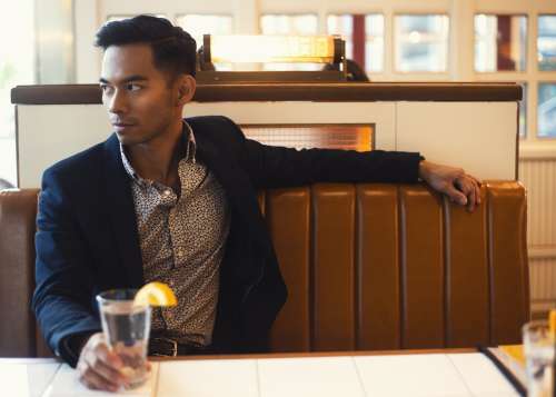 Fashionable Man Sits In Booth Photo