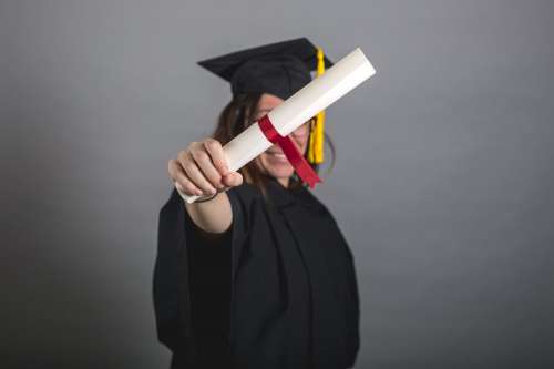 Female Grad Student Holding Out Diploma Photo