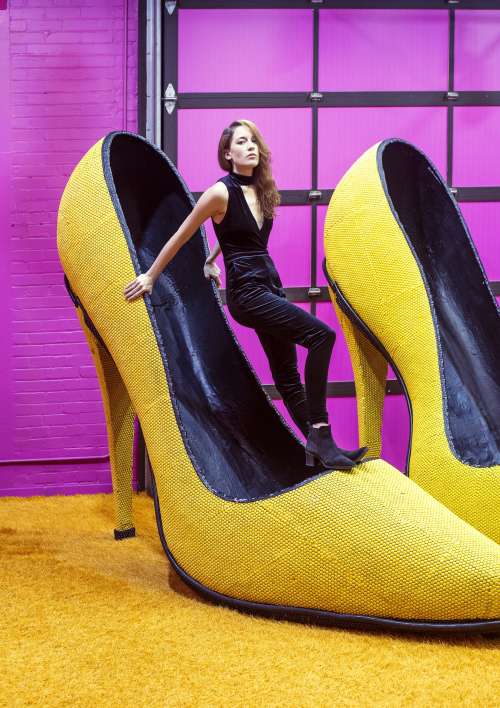 Female Model Balances Inside A Giant Yellow Shoe Photo
