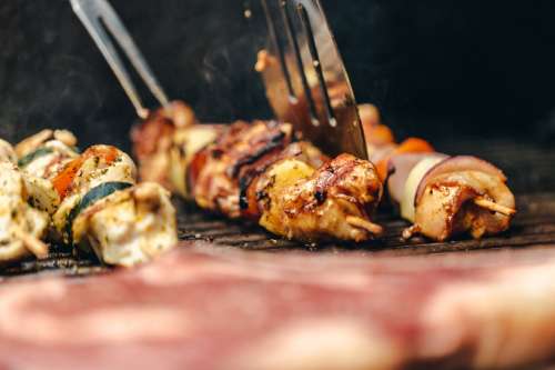 Flipping Chicken And Veggie Kabob On Grill Photo