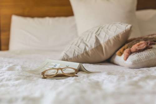 Glasses On Made Bed Photo