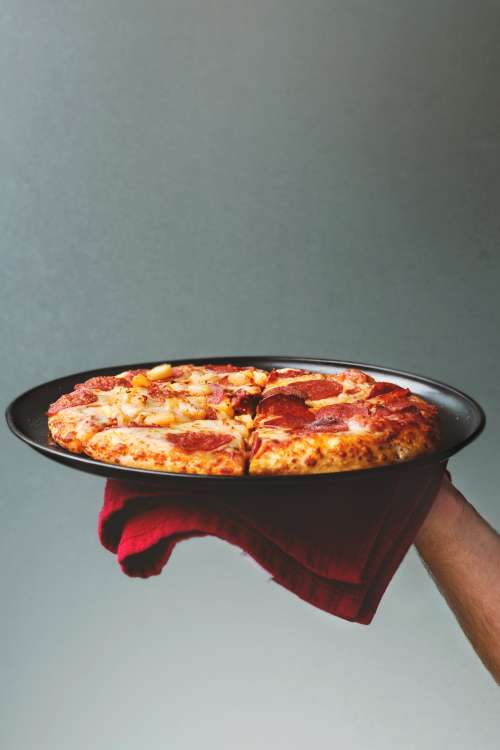 Hand Holding Oven Cooked Pizza Photo