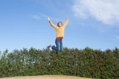 Happy Woman Jumps On Trampoline Photo