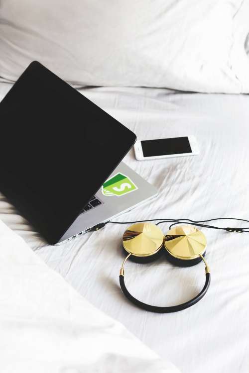 Headphones And Laptop On Bed Photo