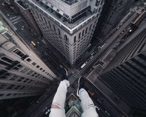 Legs Dangling Over A Heart-Stopping Drop To The City Below Photo