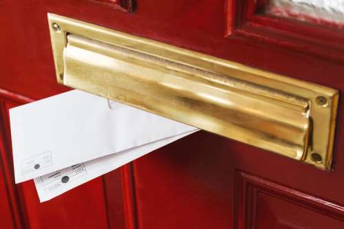 Mail Peeks Out From A Brass Letterbox Photo