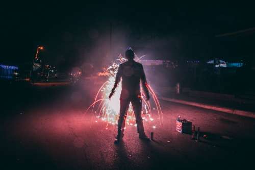 Man Setting Off Fireworks On Suburban Street Photo