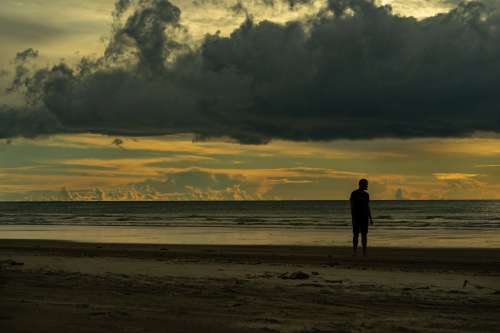 Man Thinking On Beach At Dusk Photo
