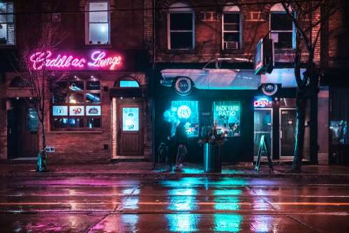 Man Walking Past Bar In Neon Light Photo