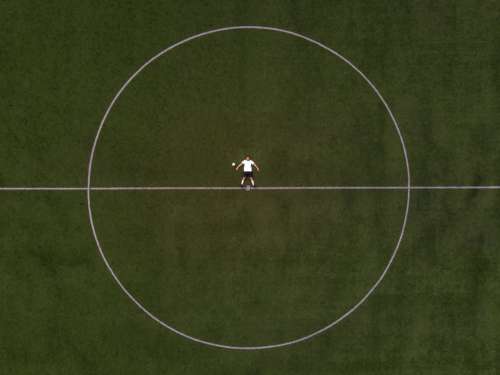 Soccer Player Laying In The Center Circle Photo