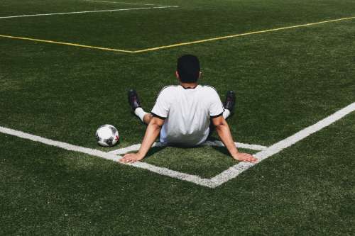 Soccer Player Sits At Field Corner Photo