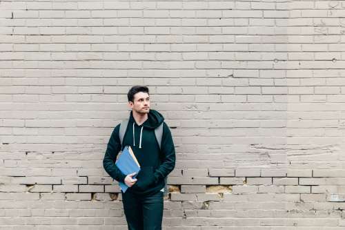Student Leaning Against Brick Wall Photo
