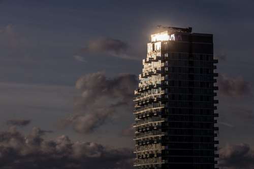 Sun Glinting Off Top Of Condo Tower Photo