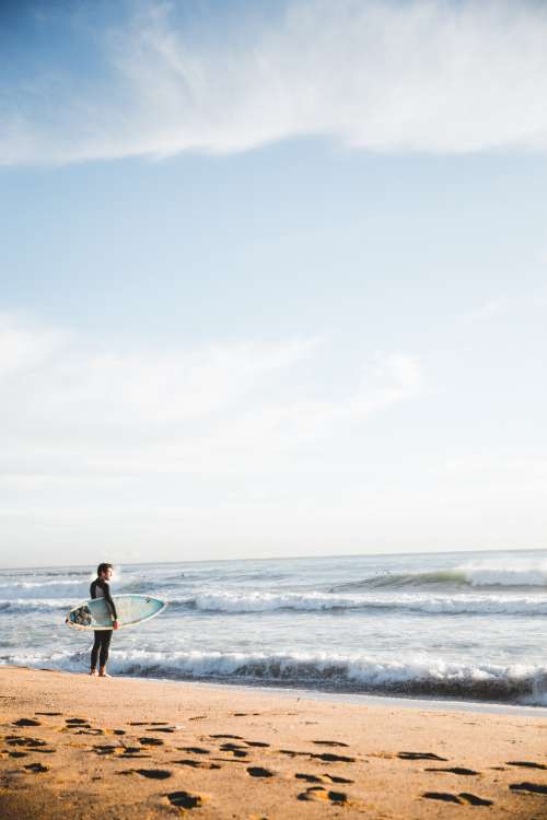 Surfer Standing By Ocean Photo