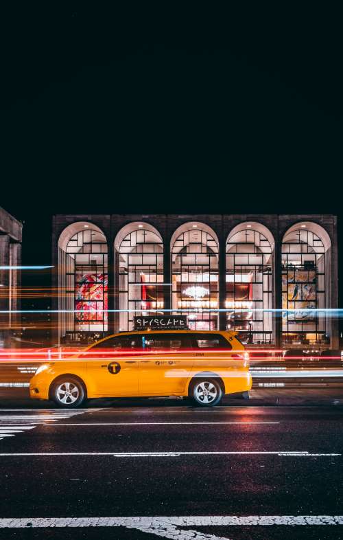 Taxi Races Past Urban Gallery At Night Photo