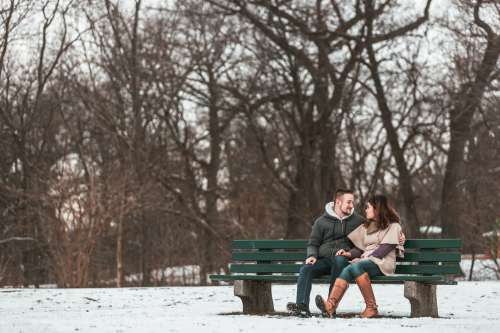 Two Lovers Smile On A Bench In The Woods Photo