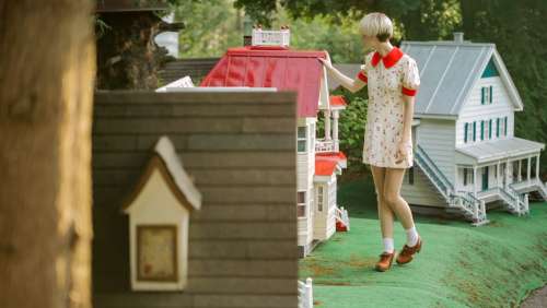 Woman And Dollhouse With Red Roof Photo