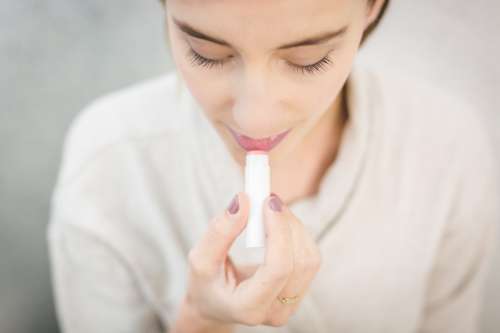 Woman Applying Lip Balm Photo