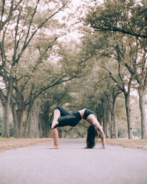 Woman Does Bridge Pose Yoga On Path Photo