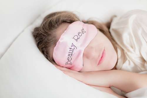 Woman In Beauty Rest Mask In Pillow Photo