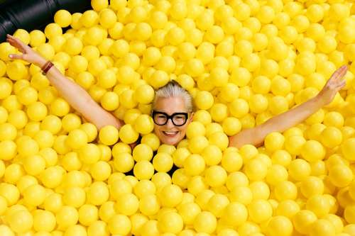 Woman In Glasses In Yellow Ball Pool Photo