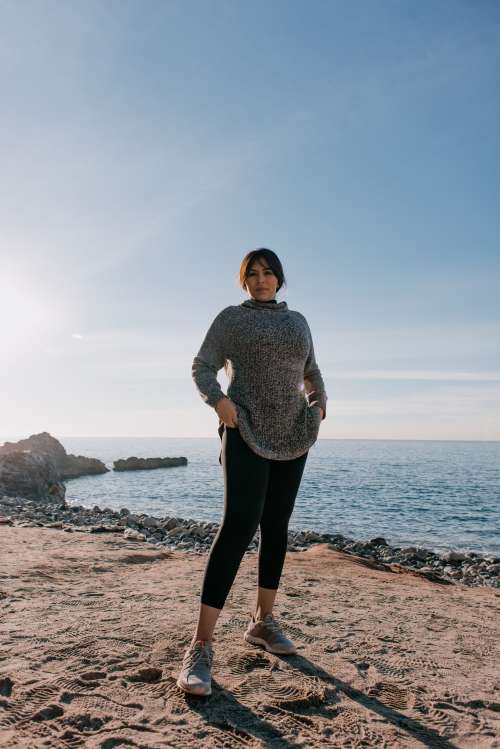 Woman In Sports Clothes Stands On A Beach In The Morning Light Photo