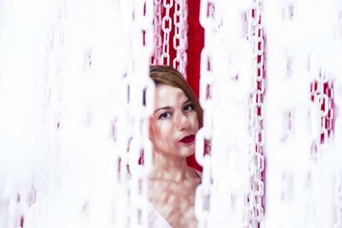 Woman Peering Out From A Curtain Of Chains Photo