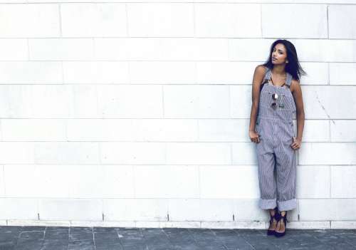 Woman Poses By Brick Wall In Overalls Photo