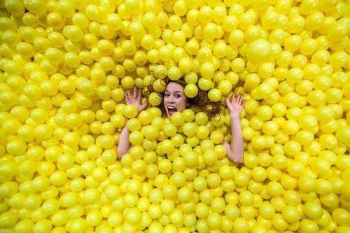 Woman Sinks Into Fun Yellow Balls Photo