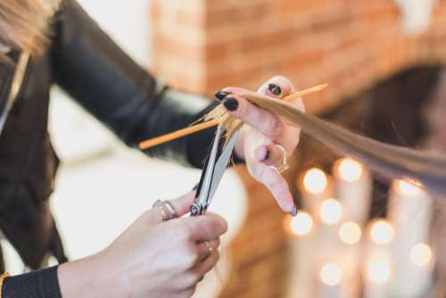 Woman Stylist Cuts Hair At Salon Photo