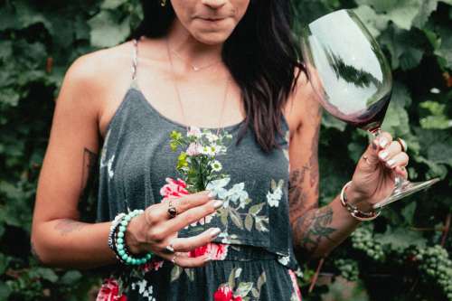 Women's Fashion Tattooed Woman Holding Flowers And Wine Photo