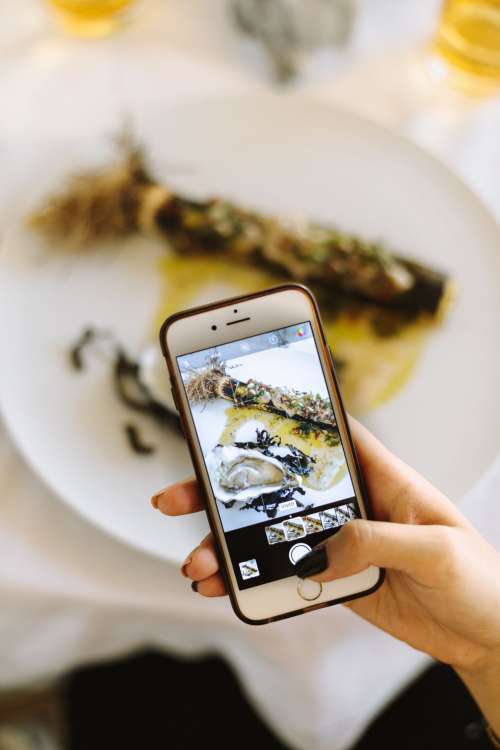 Young Woman Snaps Photo Of Food Photo