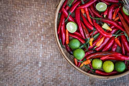 Chili peppers and limes on a wooden table